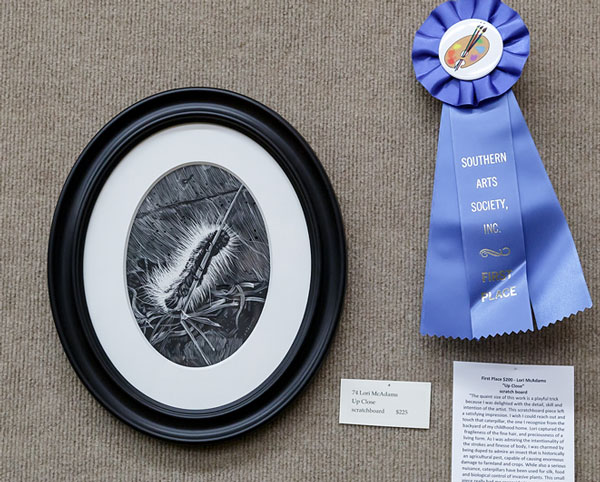 blue ribbon and drawing of caterpillar in oval frame
