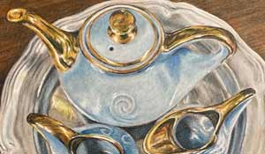 Blue and gold blue porcelain teaset on a silver platter against a wooden table.