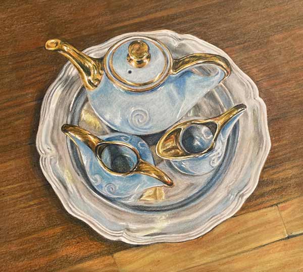 Blue and gold blue porcelain teaset on a silver platter against a wooden table.