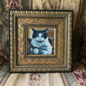 Black and white cat in an ornate frame.